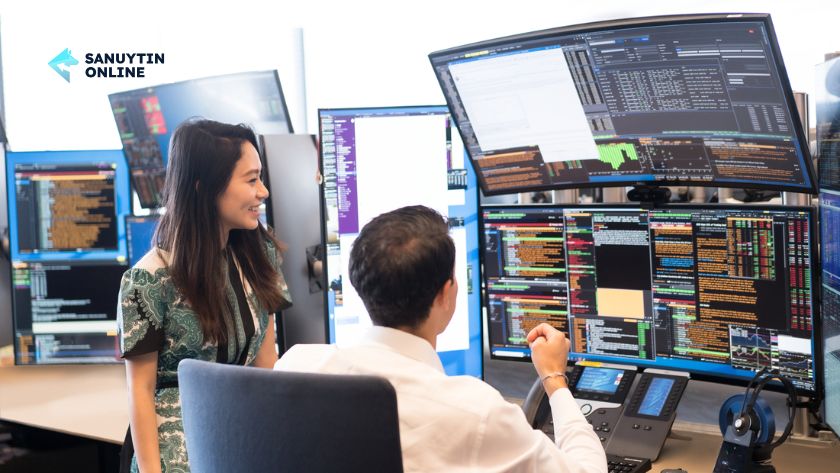 Hai trader đang phân tích dữ liệu tài chính trên màn hình.