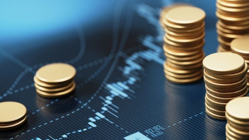 Dựa vào các loại tỷ giá để đưa ra chiến lược đầu tư an toàn, hiệu quả Các đồng xu xếp chồng lên nhau được đặt trên biểu đồ